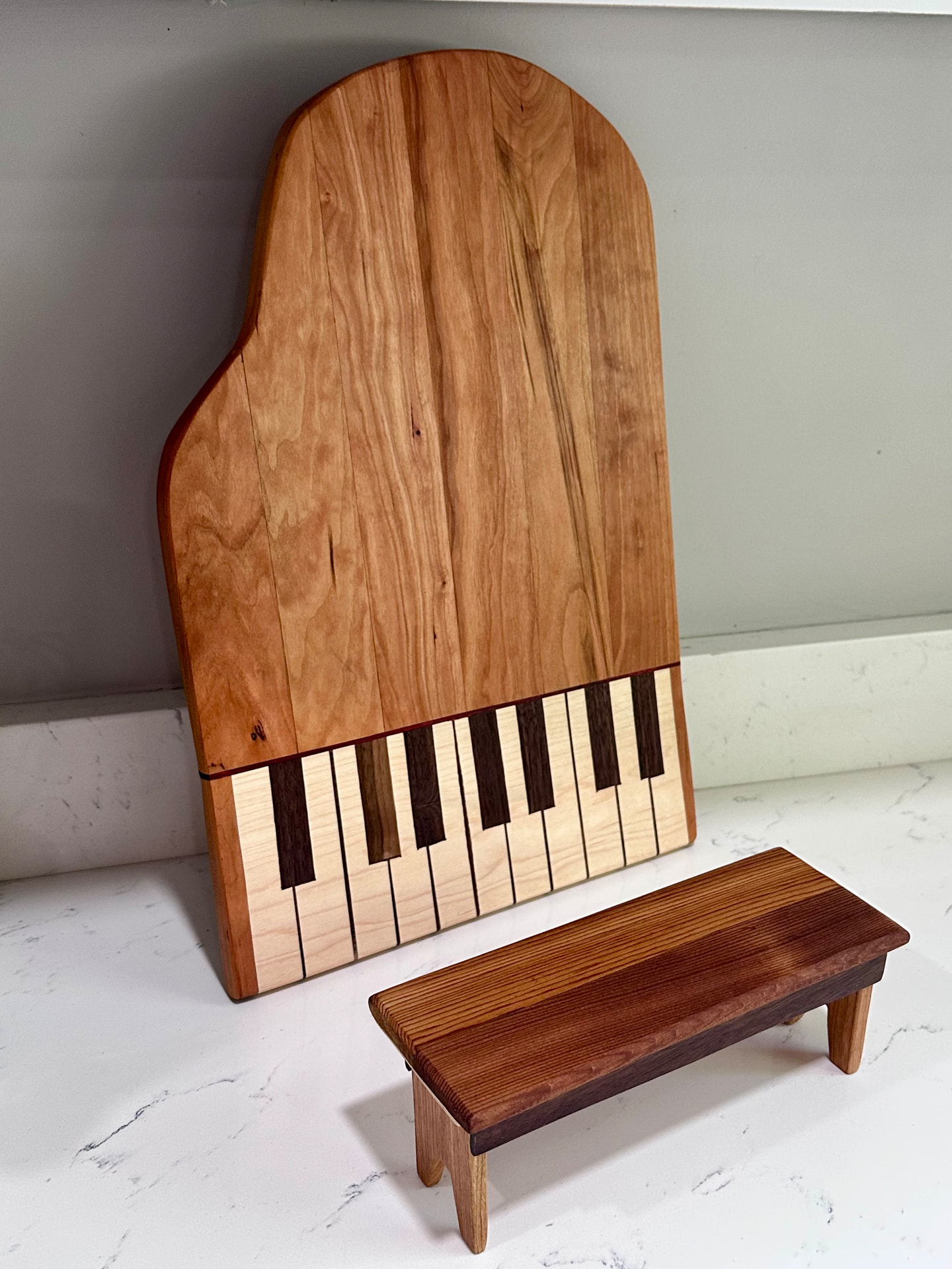Cherry and maple grand piano shaped serving board with matching bench