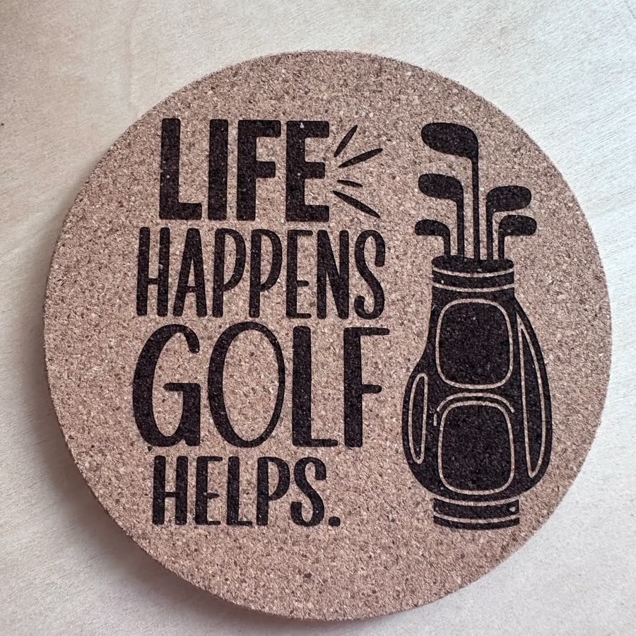 Round cork coaster engraved: Life happens, golf helps, with a golf bag