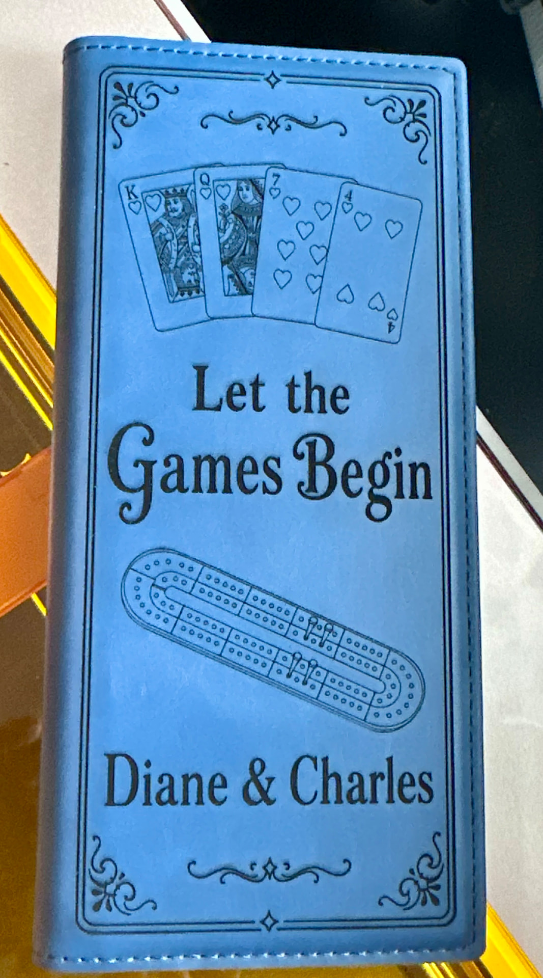 Blue leatherette journal engraved with cards, a cribbage board, and names