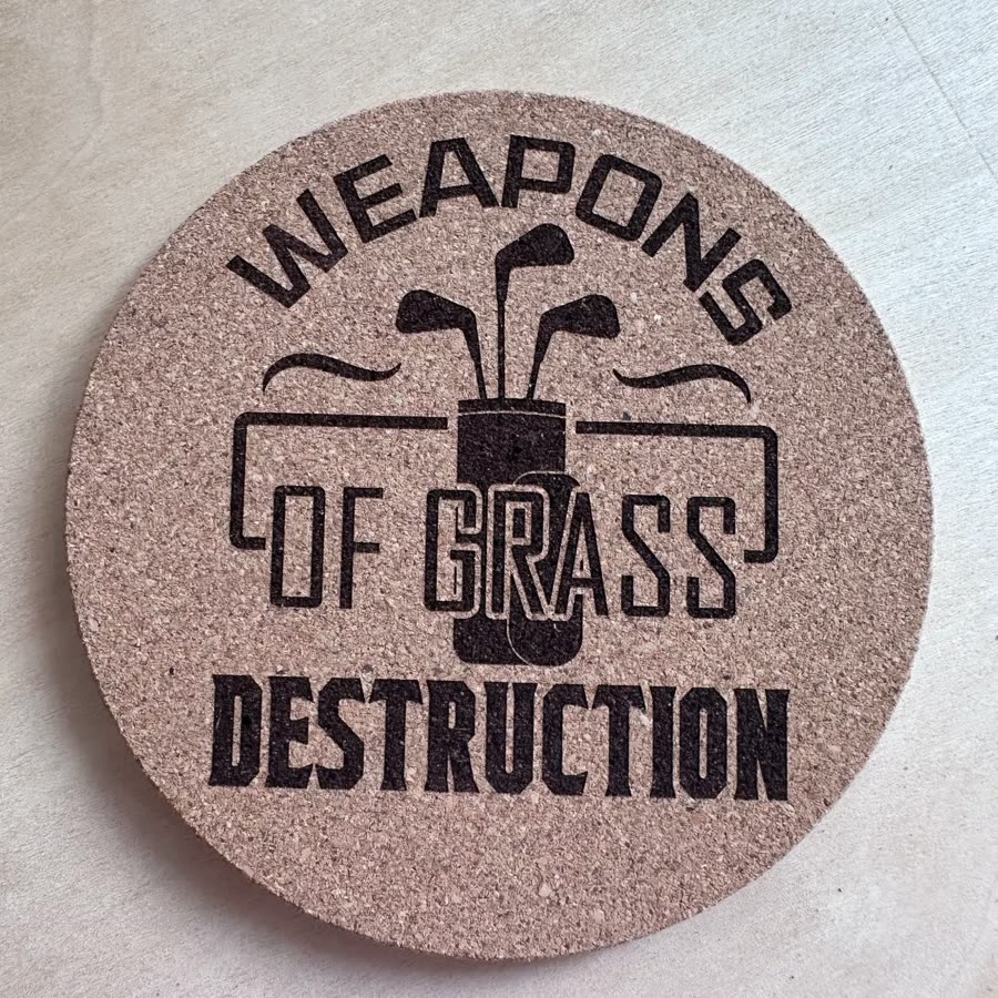 Round cork coaster engraved: Weapons of grass destruction, with a golf bag
