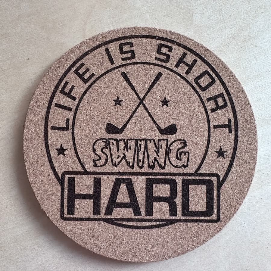 Round cork coaster engraved: Life is short, swing hard, with crossed golf clubs