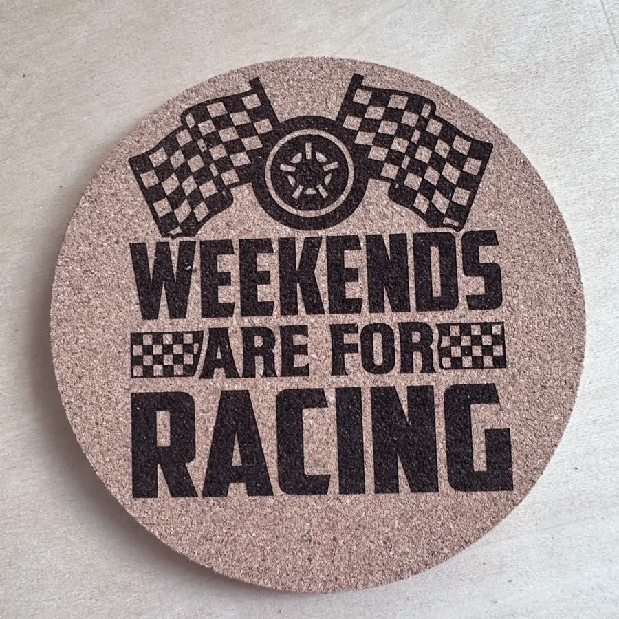 Round cork coaster engraved: Weekends are for racing, with checkered flags